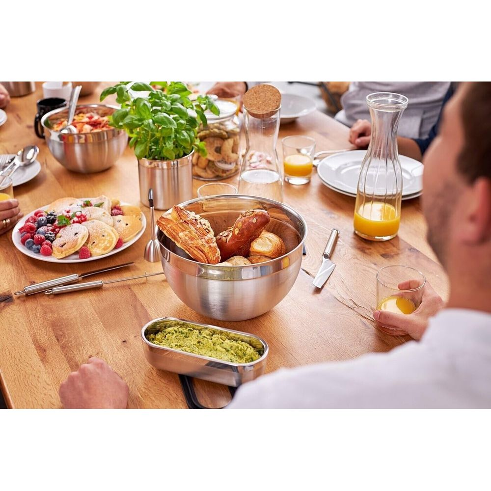 Frühstückstisch mit Gebäck, Pfannkuchen, Beeren, Orangensaft und Dip.