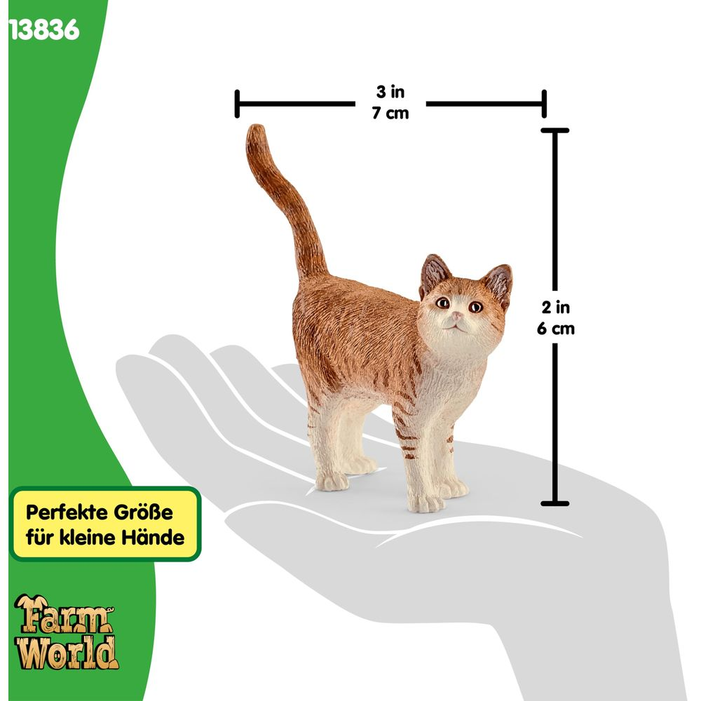 Pomarańczowy pręgowany kot stoi na dłoni. Wymiary 7x6cm.