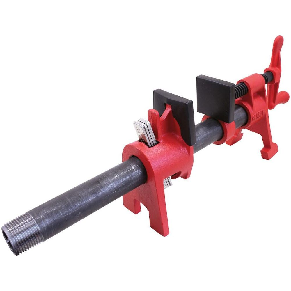 Ein roter Rohrspannwerkzeug klemmt ein Metallrohr mit Gewinde an einem Ende.