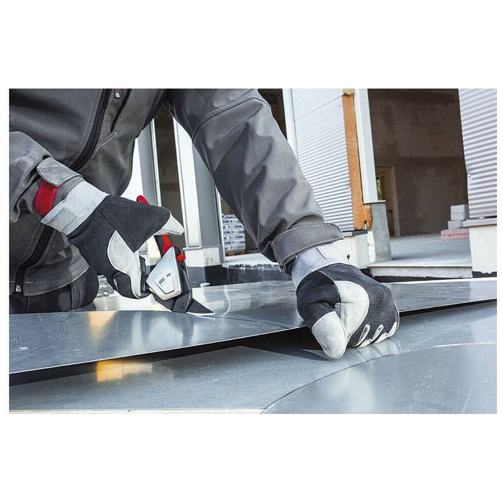 Handwerker schneidet Metallblech mit Schere, trägt Arbeitshandschuhe.
