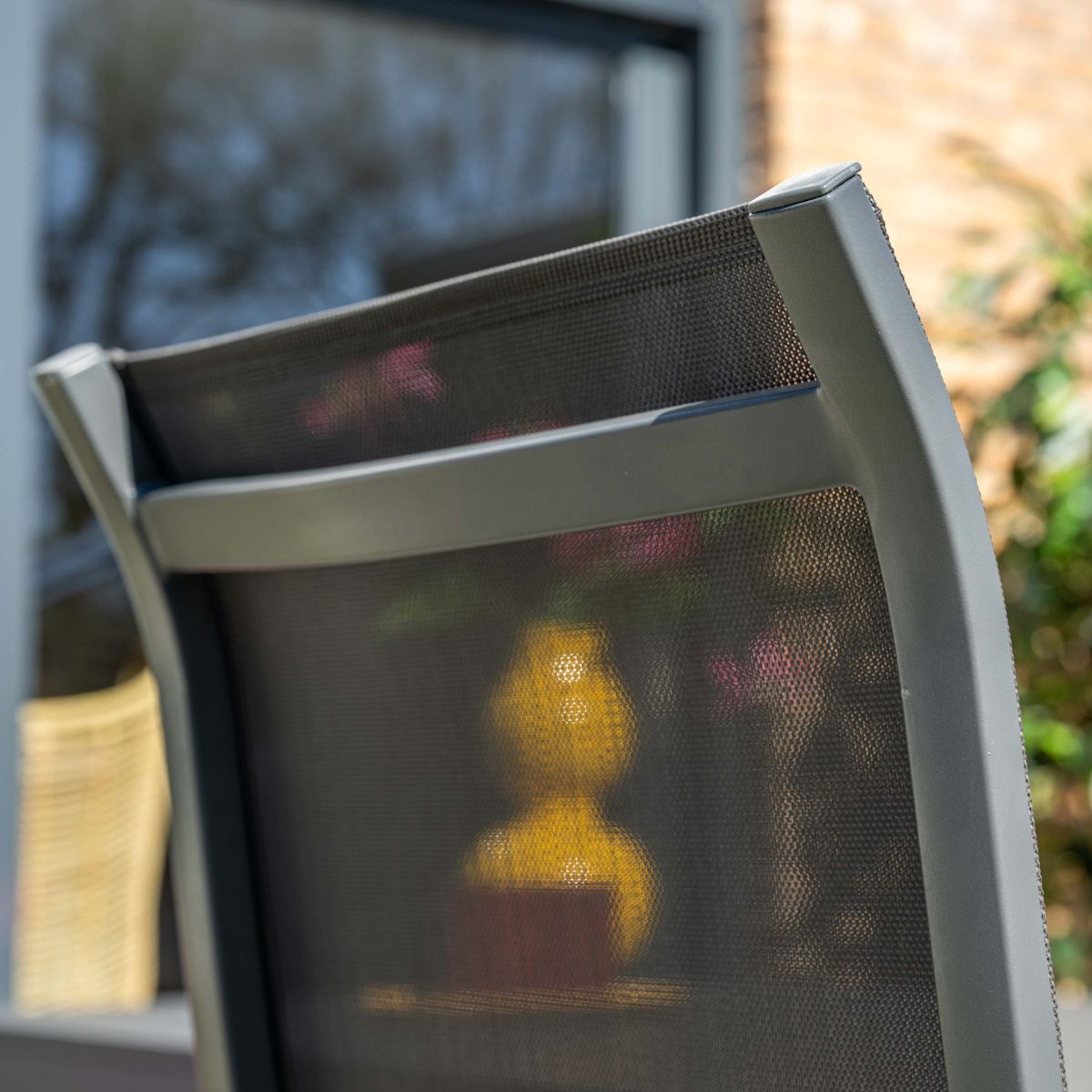 Grijze stoel met netbespanning en gele kan op achtergrond.