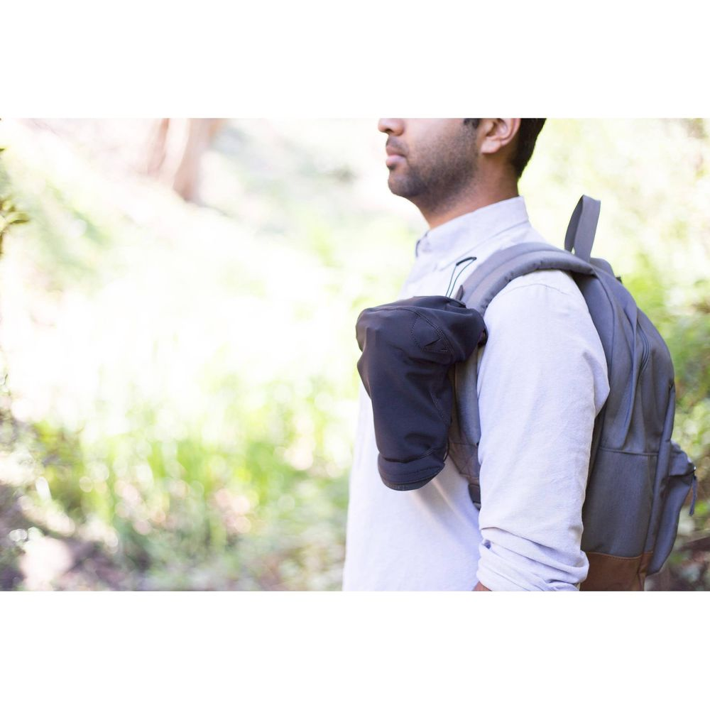 Man wearing backpack with black pouch, outdoors.