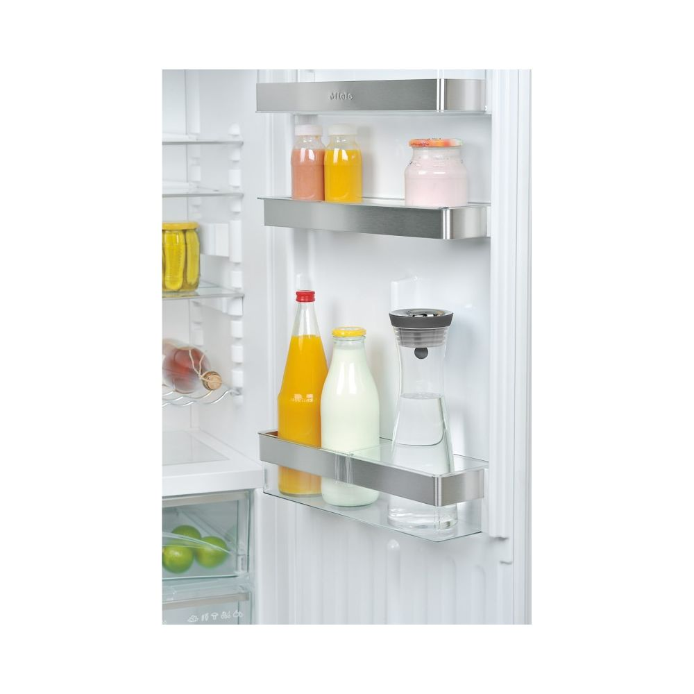 Kühlschrankregale mit Flaschen und Gläsern: Saft, Milch, Wasser, Joghurt.