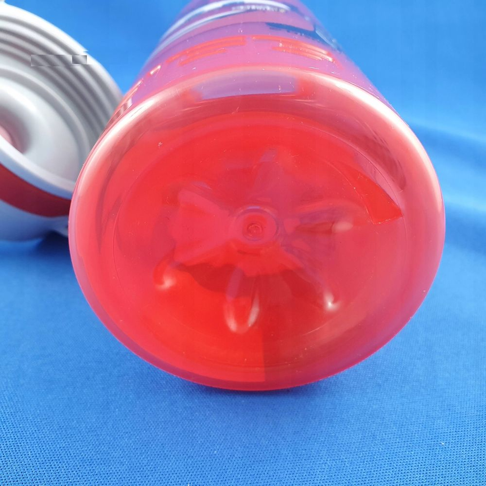 Nahaufnahme einer roten Plastikwasserflasche mit weißem Deckel auf blauem Stoff.