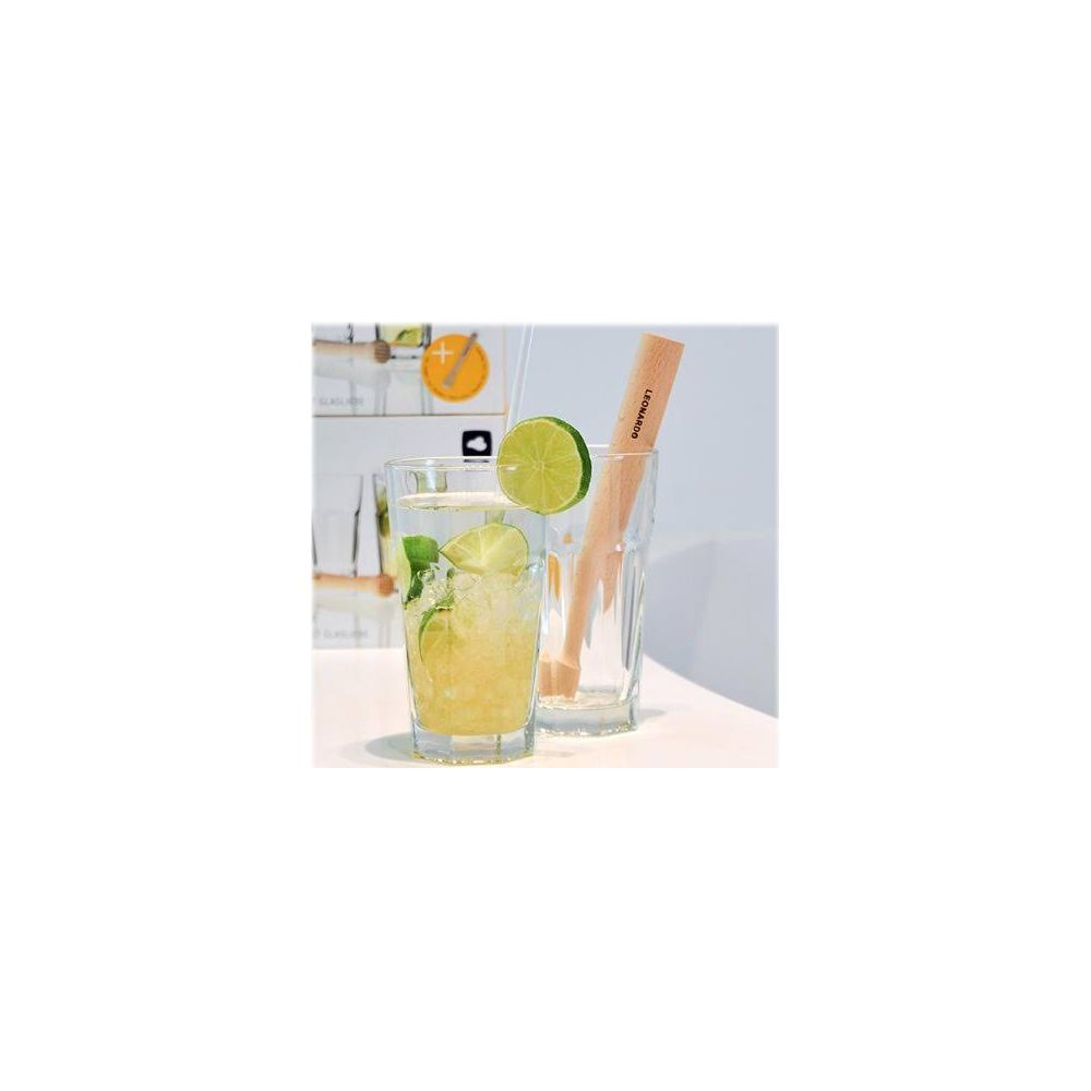 Ein Glas mit einem Getränk, Eis, Limettenscheiben und Minze. Daneben ein leeres Glas mit Holzstößel.