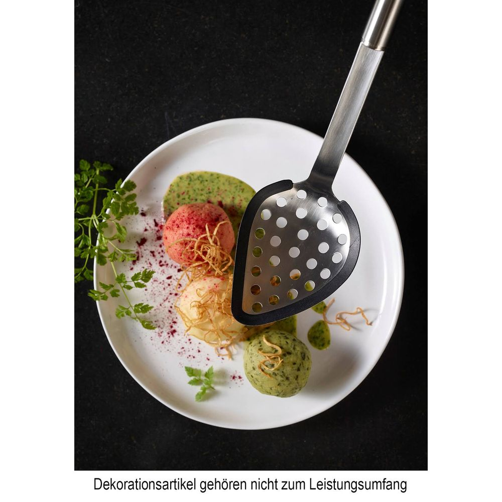 Ein Löffel über einer weißen Platte mit bunten Speisen und Soßen.