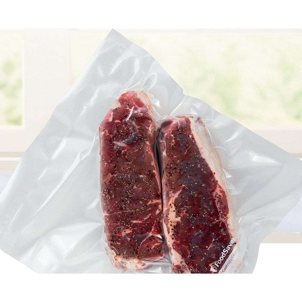 Zwei vakuumverpackte Steaks mit Pfeffer gewürzt auf einem weißen Hintergrund.