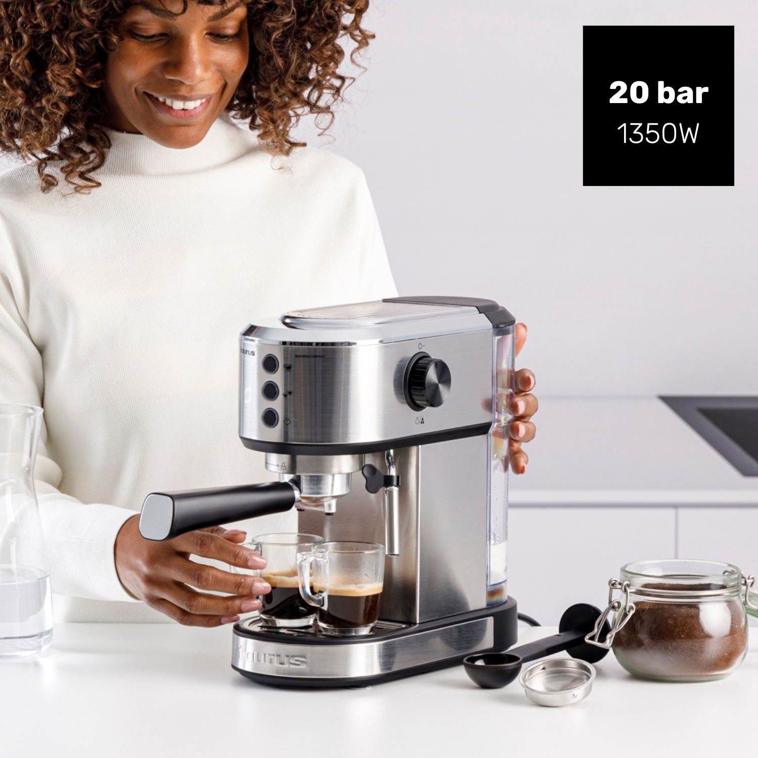 Mujer prepara espresso con máquina plateada, dos tazas están llenas.
