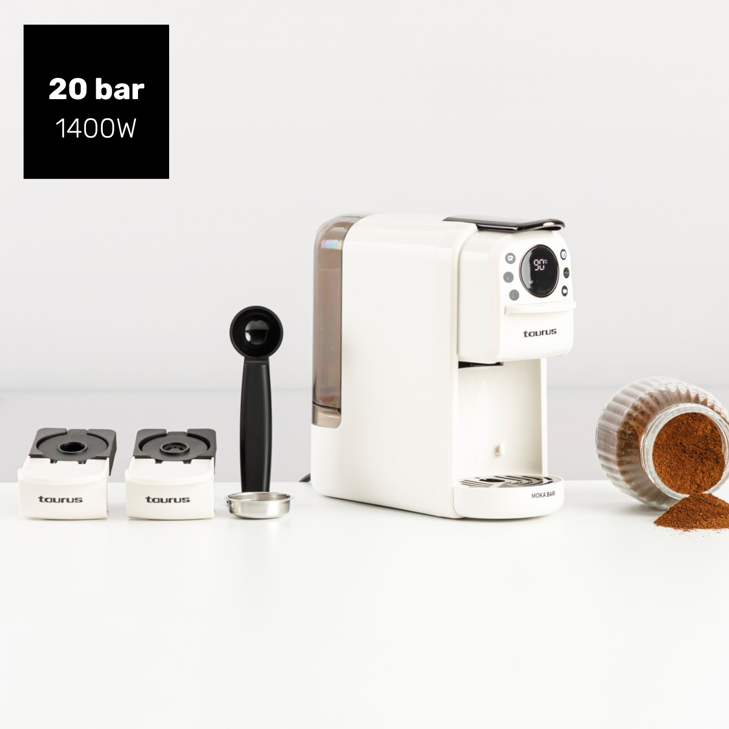 Una cafetera blanca con accesorios y café molido sobre una mesa.