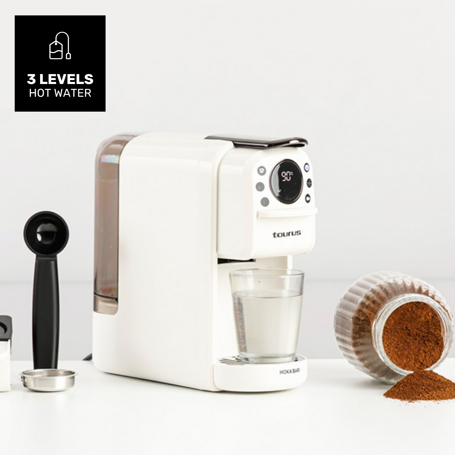 Cafetera blanca con vaso, posos de café y accesorios.