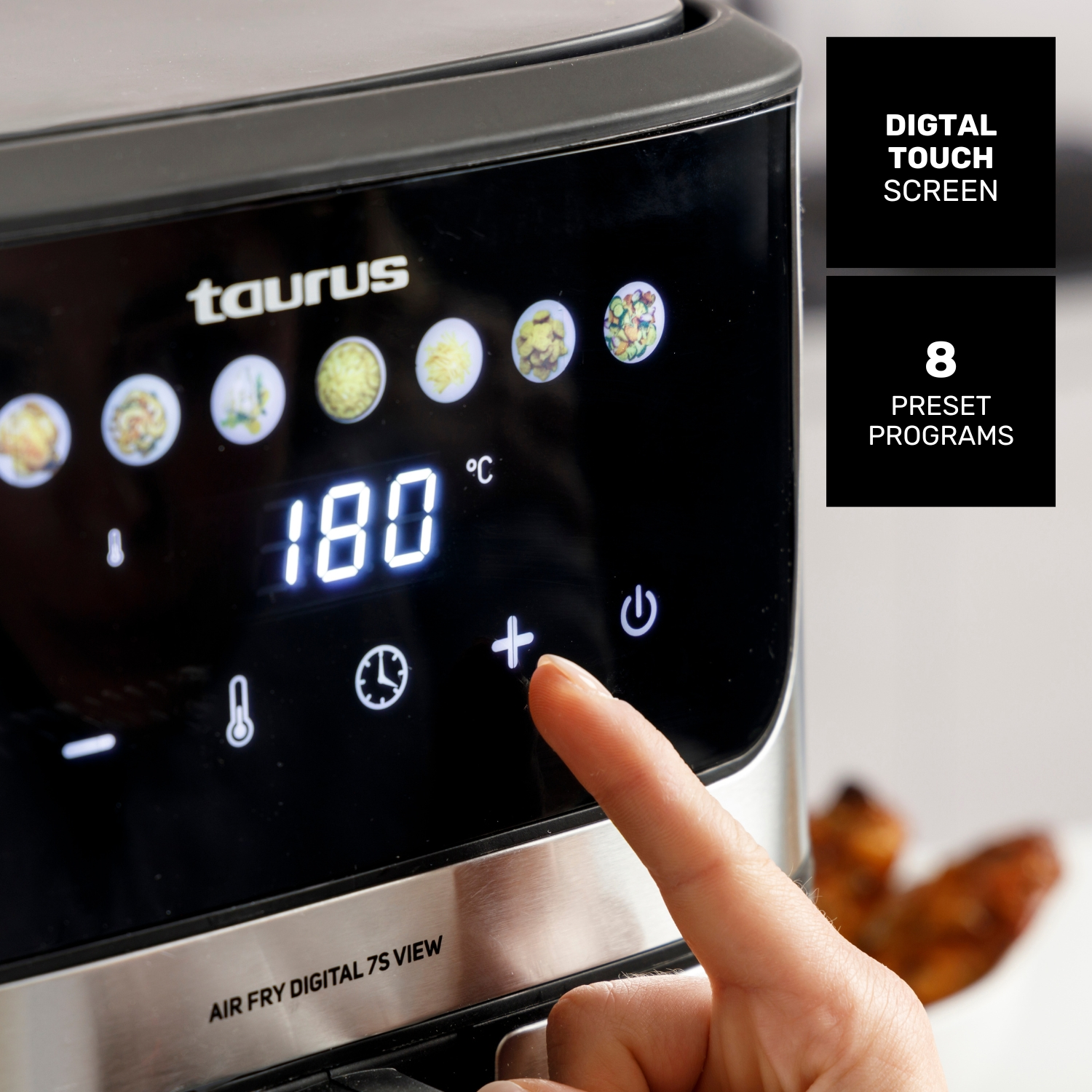La pantalla digital de la freidora de aire Taurus muestra 180°C. Un dedo pulsa el botón más.