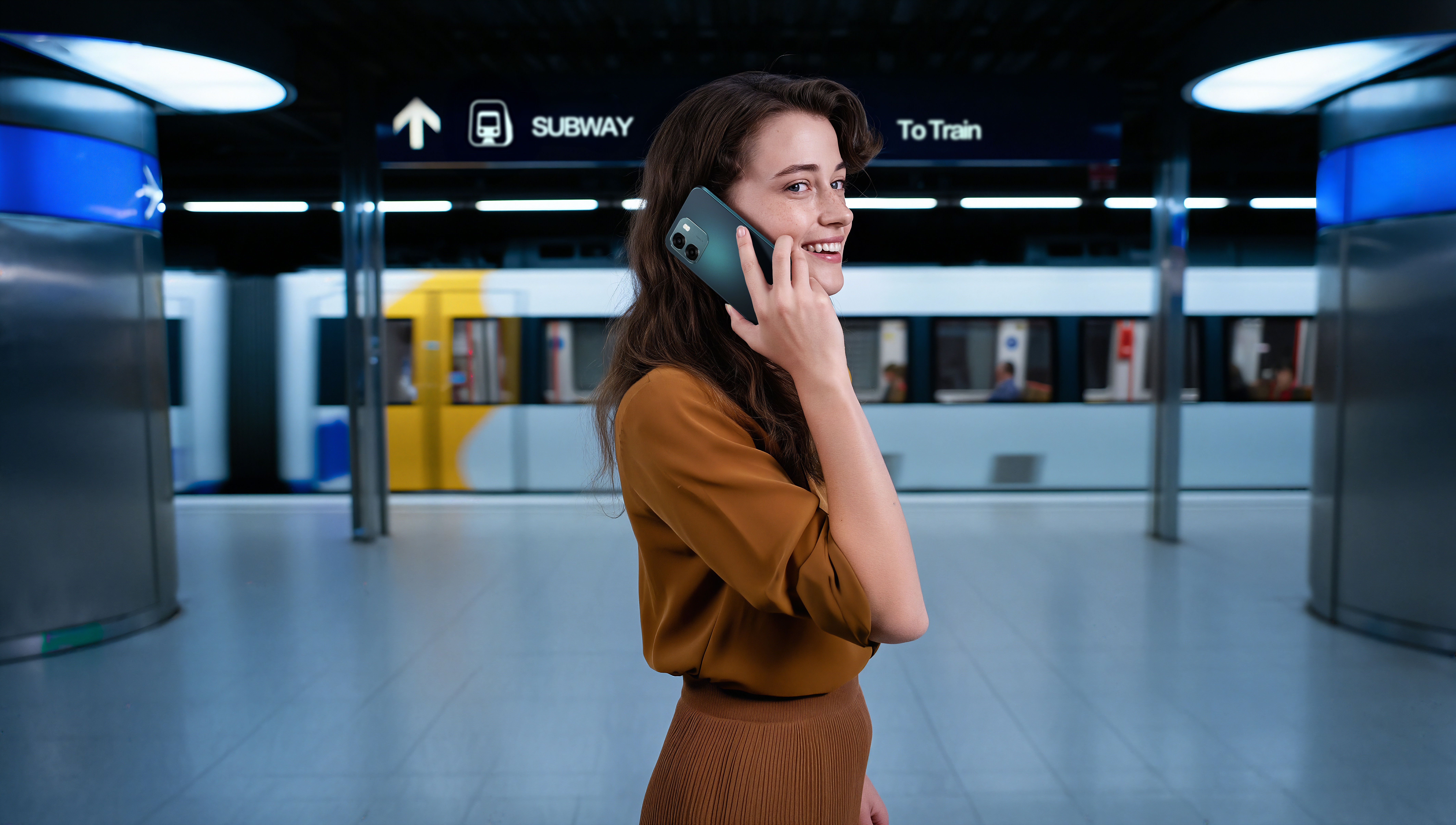 Een vrouw belt met een trein op de achtergrond in een metrostation.