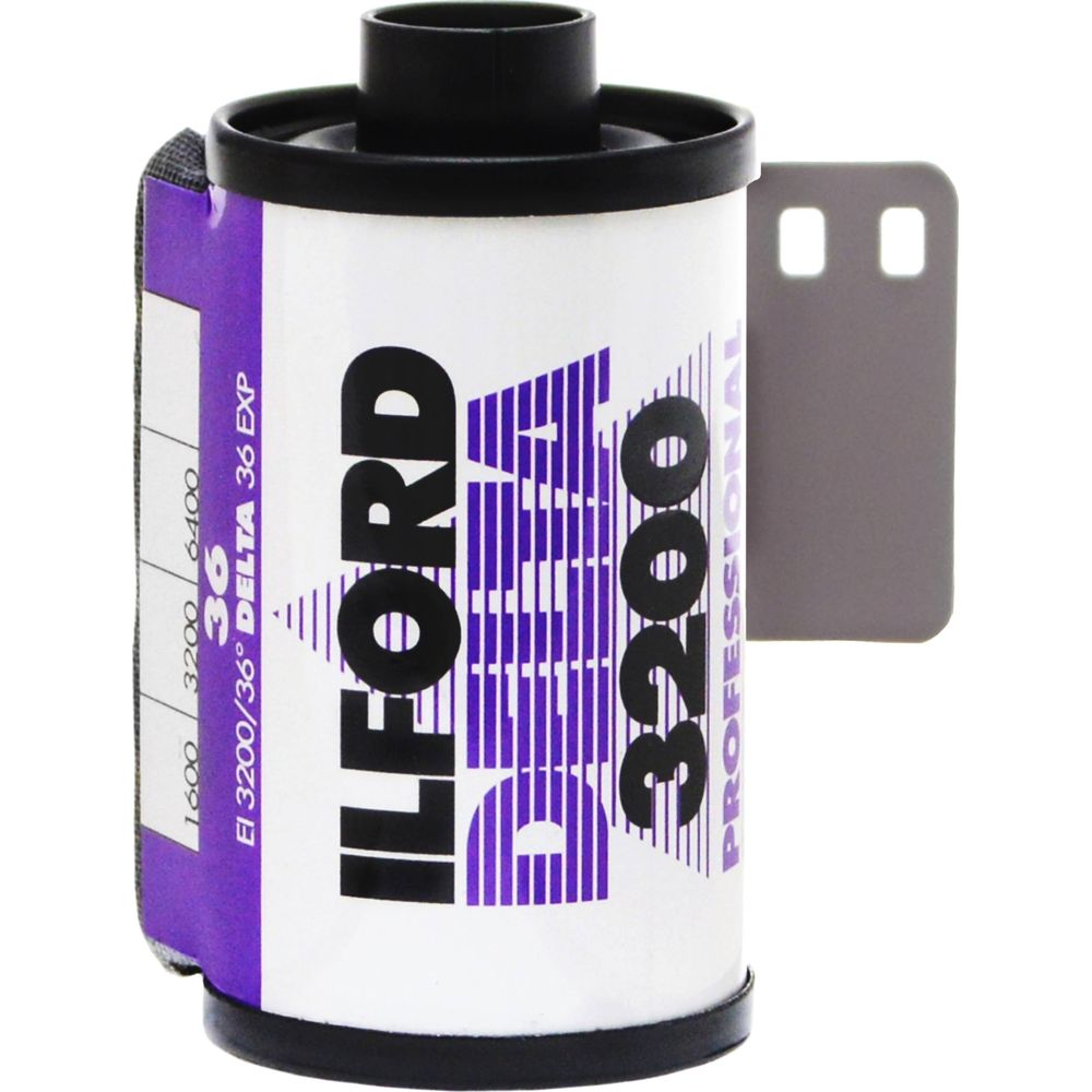 Rolka filmu Ilford Delta 3200 z czarną nakrętką i szarym papierem podkładowym.