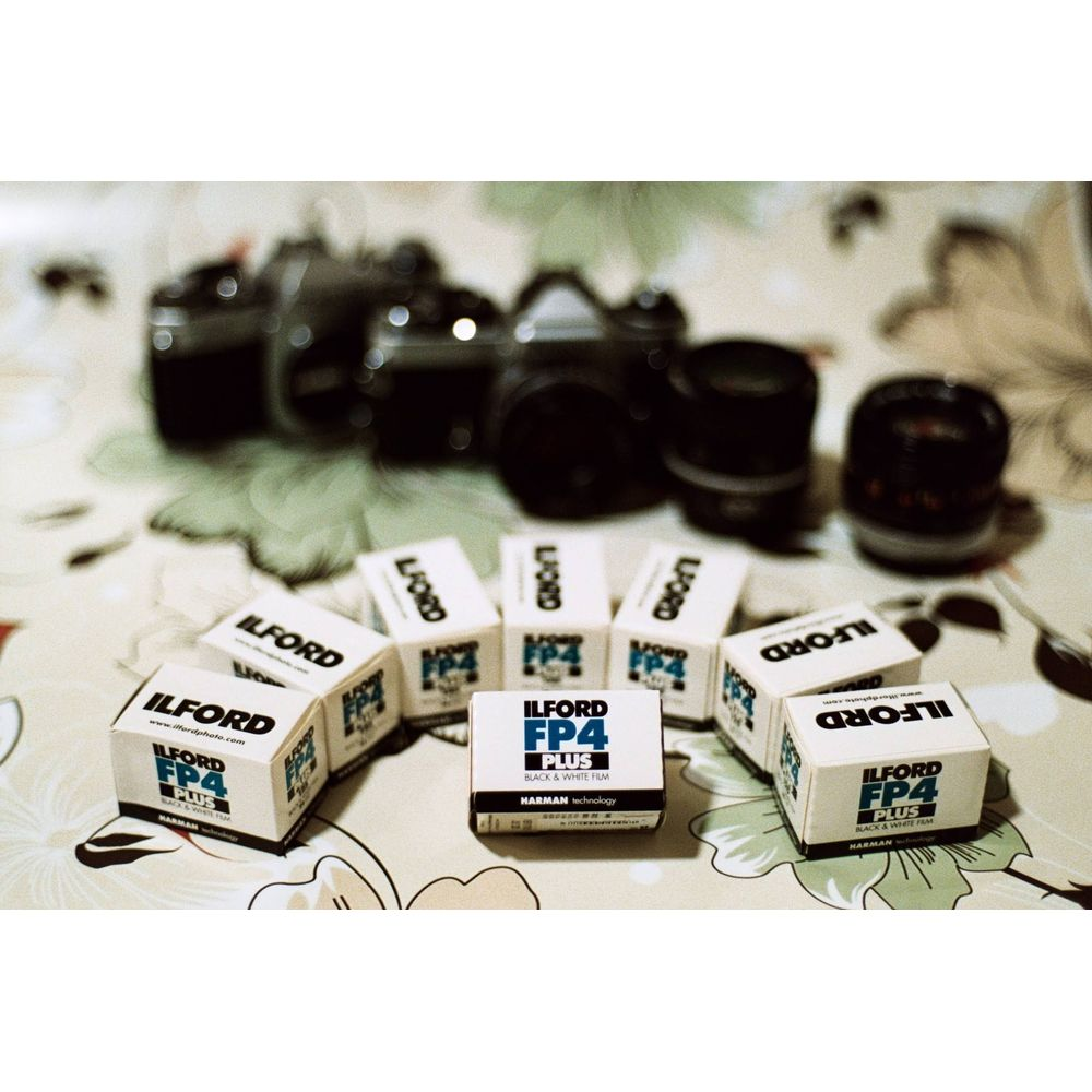 Kilka pudełek czarno-białej folii Ilford FP4 Plus przed aparatem.