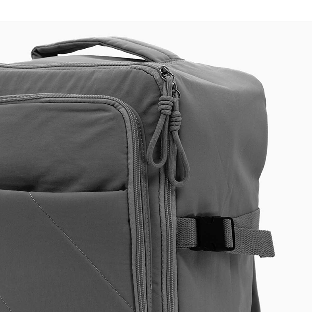 Mochila gris con cremalleras, tiradores de cordón y hebilla.