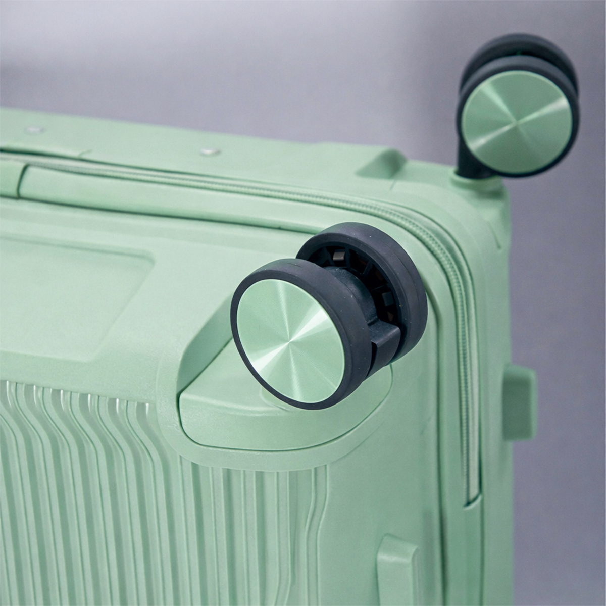 Maleta verde con dos ruedas, primer plano.