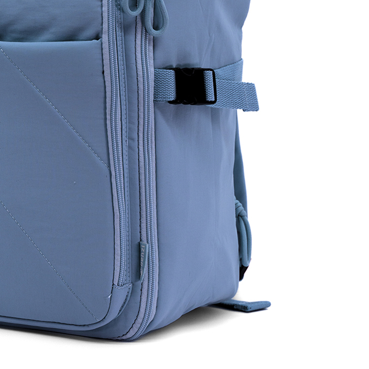 Una mochila azul con cremalleras y una correa con hebilla negra.