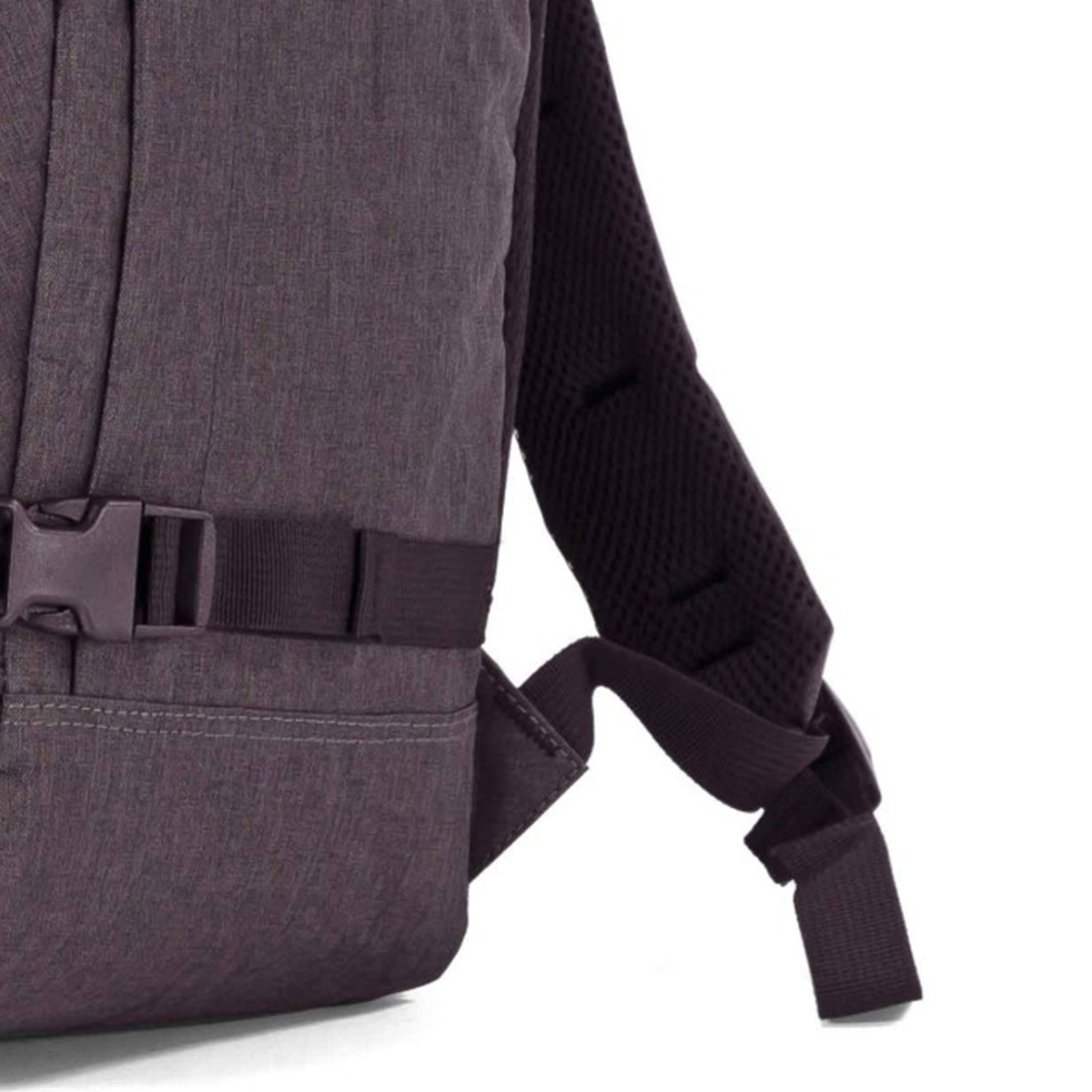 Primer plano de una mochila oscura con hebilla y correa de hombro acolchada.