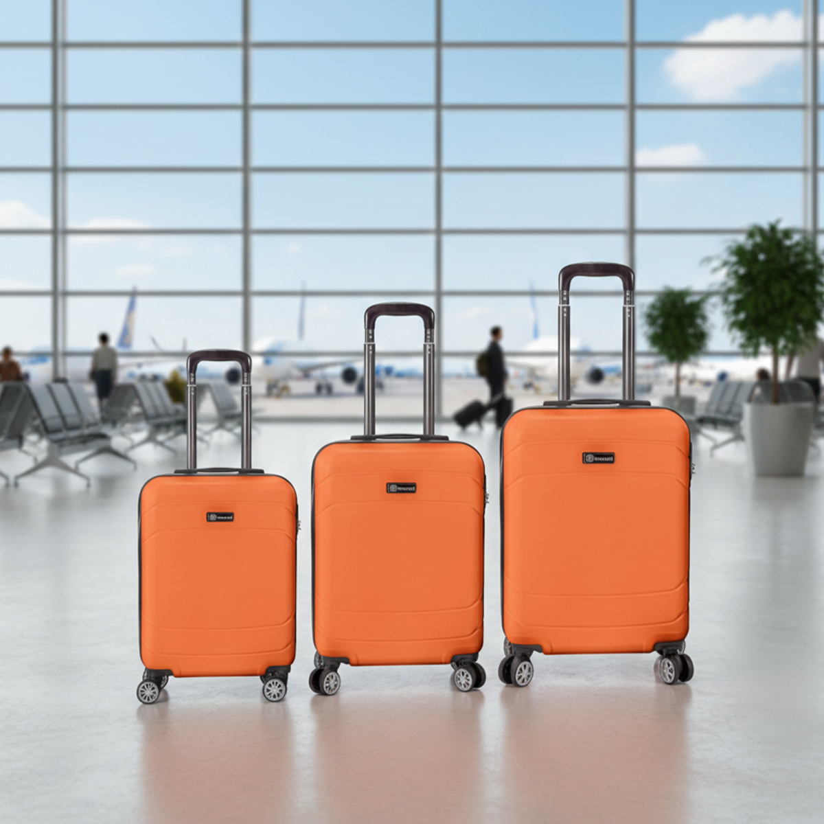 Tres maletas naranjas de diferentes tamaños en una sala de espera de aeropuerto.
