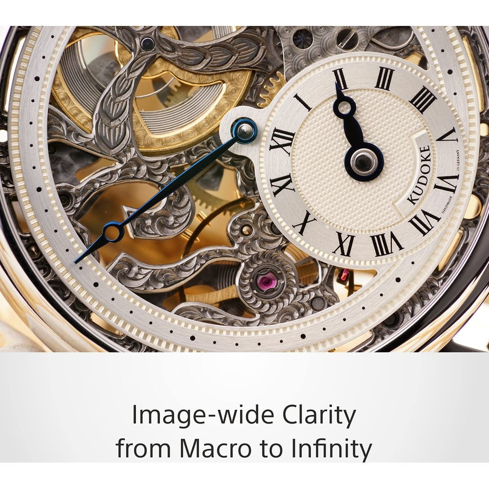 Zbliżenie ozdobnego mechanizmu zegarka z rzymskimi cyframi i złotymi zębatkami.