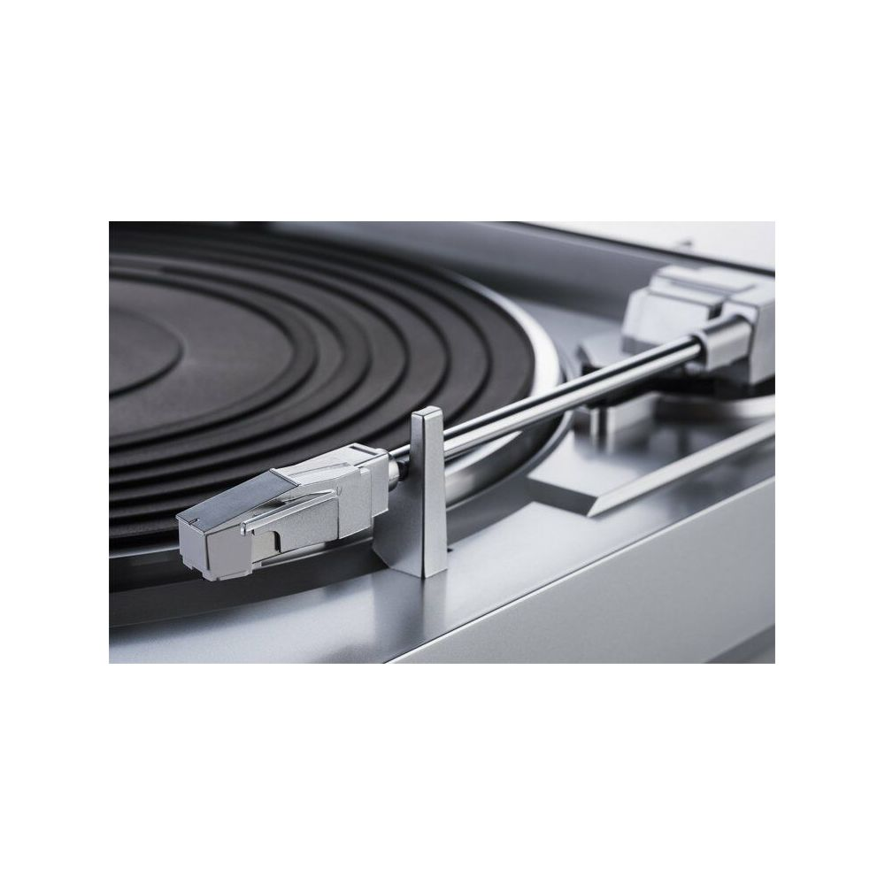 Zbliżenie srebrnego ramienia gramofonu na czarnej płycie.