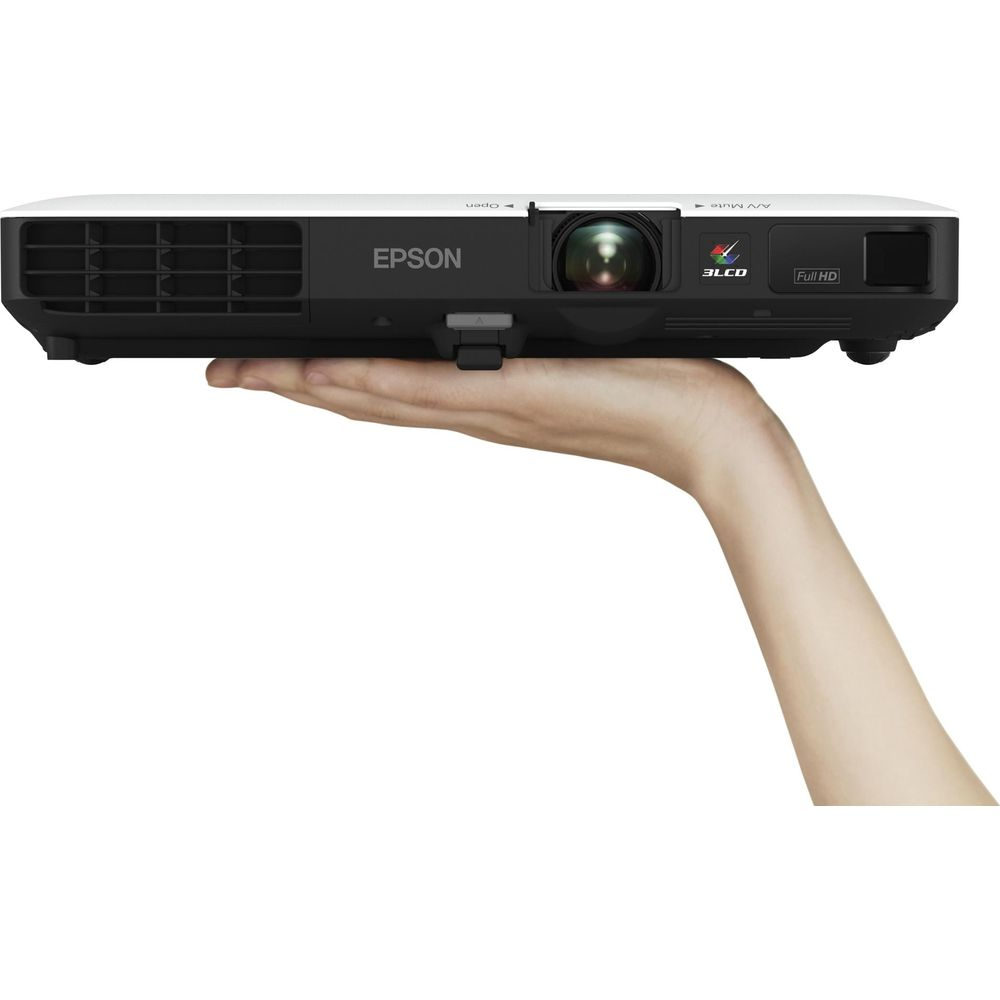 Eine Hand hält einen weißen Epson Projektor mit schwarzer Lünette und Linse.