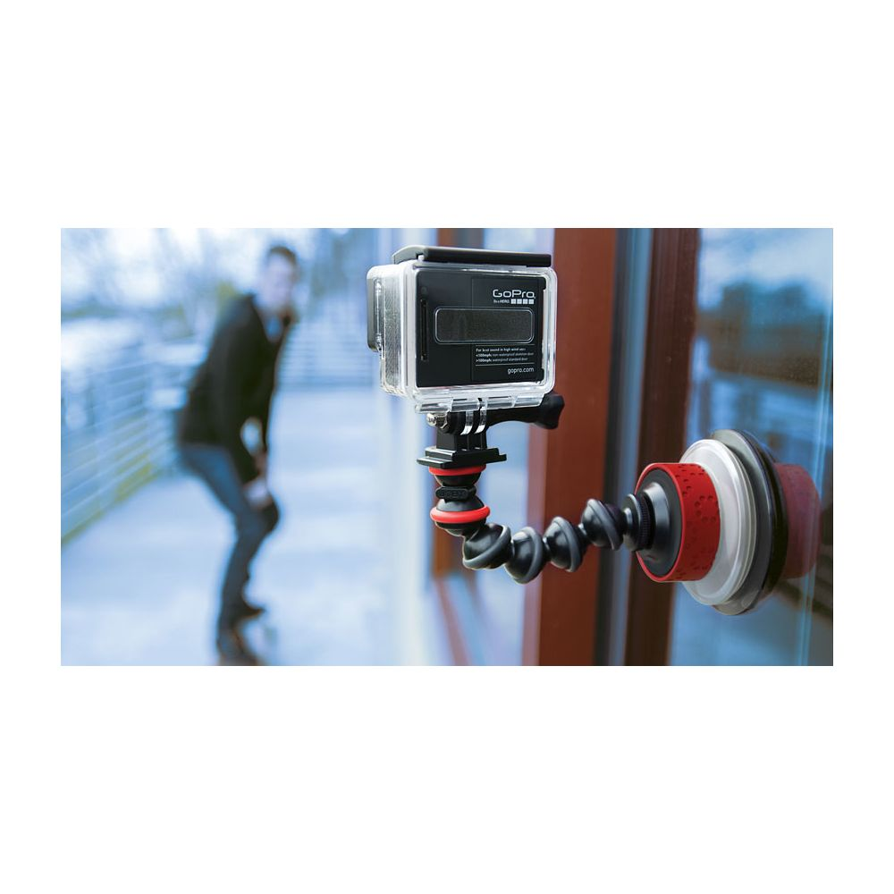Una videocamera GoPro è fissata a un treppiede flessibile con ventosa su una finestra.