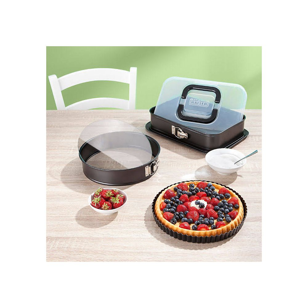 Tarta owocowa w formie, obok miski truskawek i formy do ciasta.