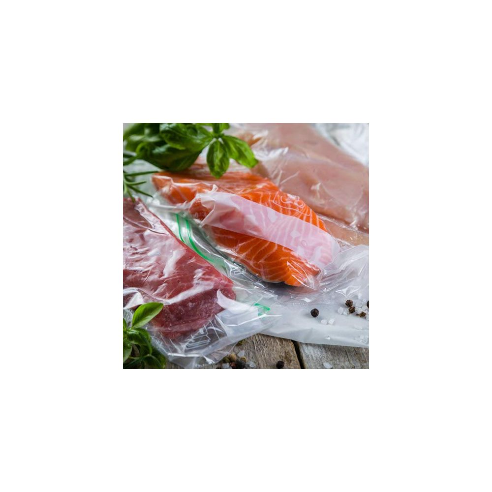 Carne cruda, salmone e pollo in sacchetti di plastica su tavolo di legno con erbe.