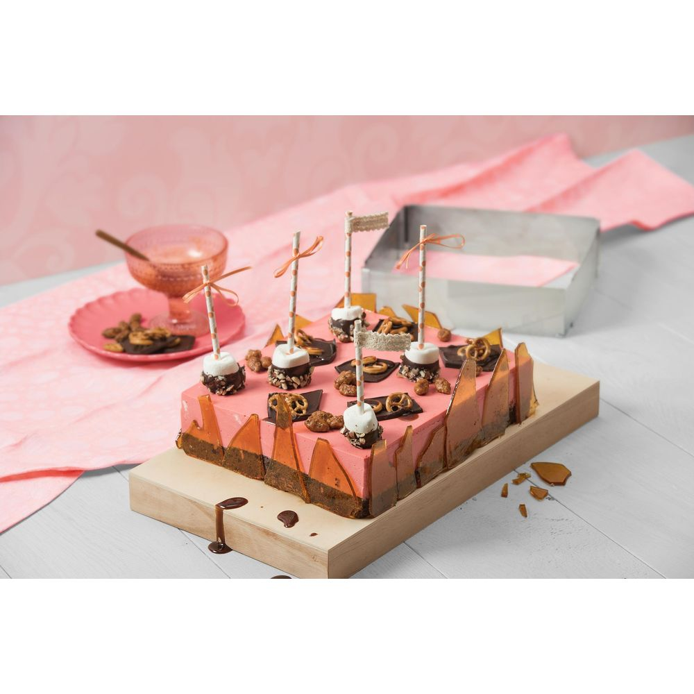 Ein rechteckiger Kuchen mit rosa Glasur, dekoriert mit Marshmallows, Brezeln und Karamellstücken.