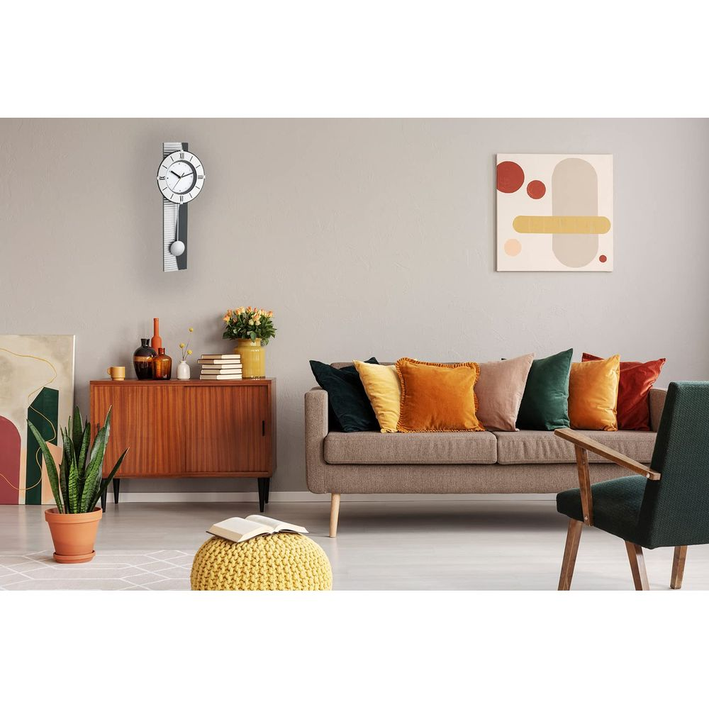 Ein Wohnzimmer mit einem braunen Sofa, Kissen, einem Schrank und einer Wanduhr.