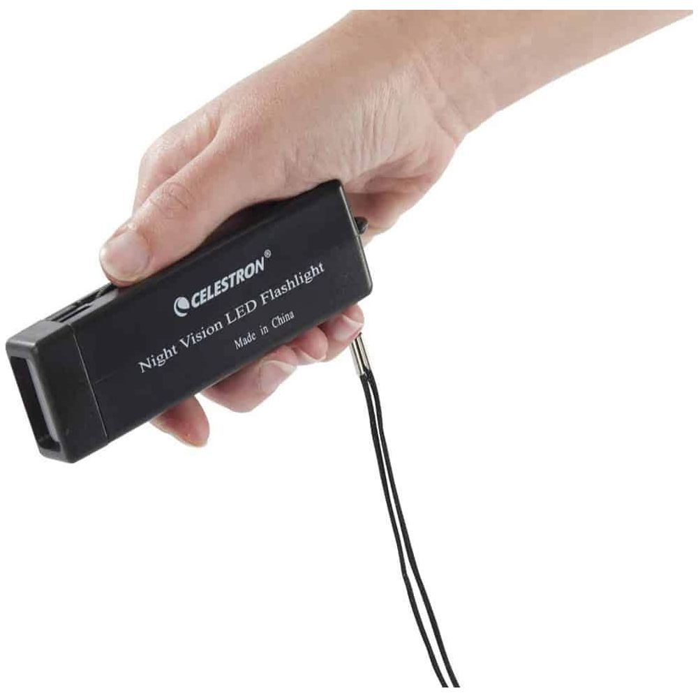 Eine Hand hält eine schwarze Celestron LED-Taschenlampe für Nachtsicht mit einer Schnur.