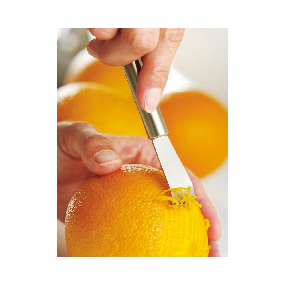 Eine Hand schält mit einem Zestenreißer die Schale einer Orange ab.