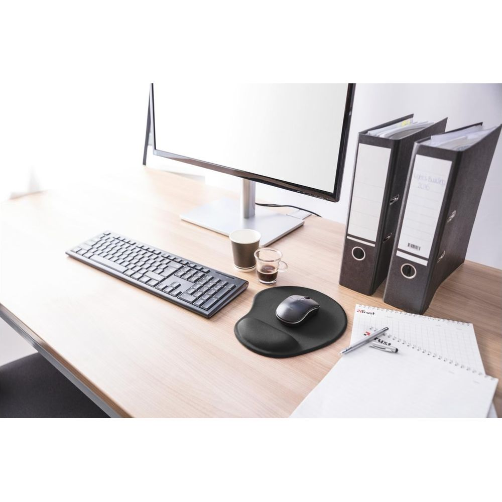 Un bureau avec un moniteur, un clavier, une souris, deux classeurs, un carnet et du café.