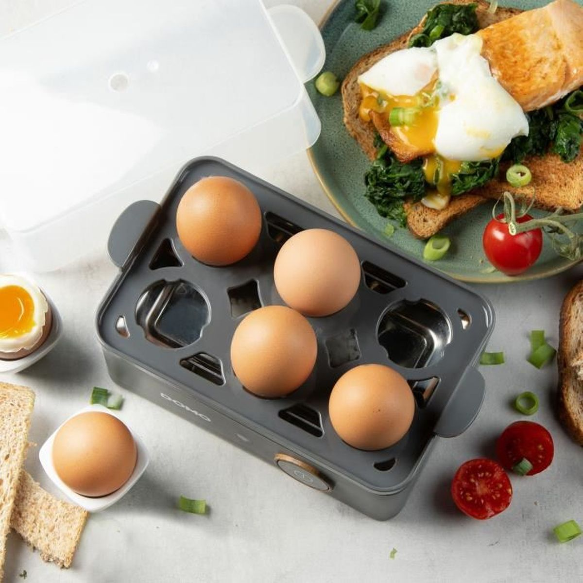 Urządzenie do gotowania jajek z jajkami, tostami i łososiem na talerzu.