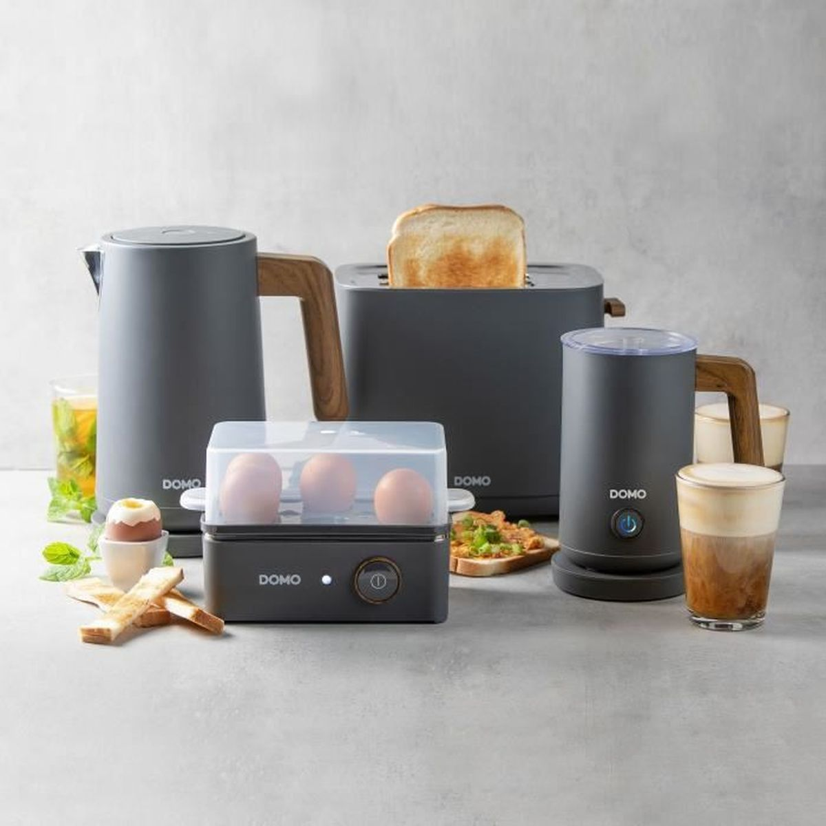 Urządzenia kuchenne: czajnik, toster, parowar do jajek, spieniacz do mleka z tostami i kawą.