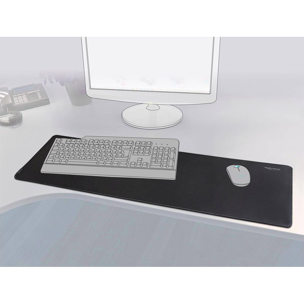Graue Tastatur und Maus auf einem schwarzen Mauspad vor einem Computermonitor.