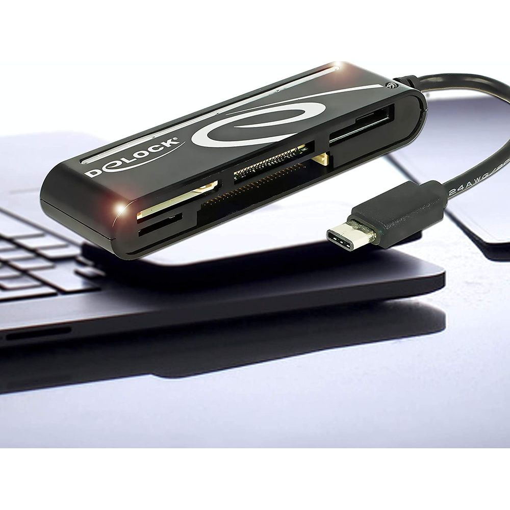 Un lettore di schede nero con connettore USB-C poggia sulla tastiera di un laptop.