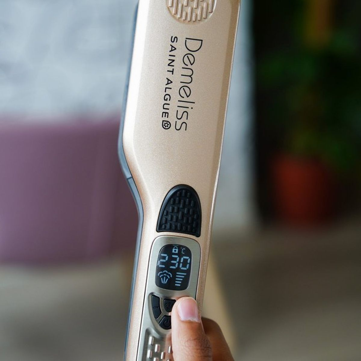 Una piastra per capelli dorata con display digitale a 230 gradi Celsius.