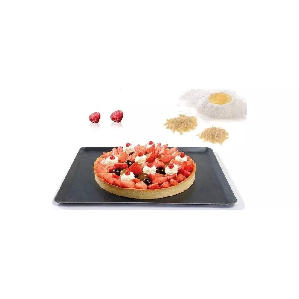 Obstkuchen mit Beeren und Sahne auf einem schwarzen Tablett.