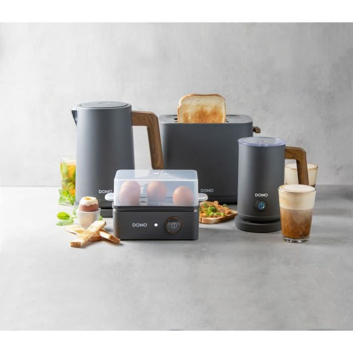Graue Küchengeräte: Wasserkocher, Toaster, Eierkocher, Milchaufschäumer, Toast, Ei, Kaffee.