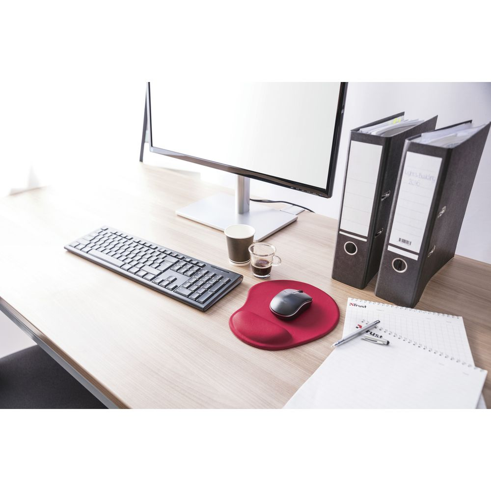 Bureau avec clavier, souris sur tapis rouge, moniteur, deux classeurs et carnet.
