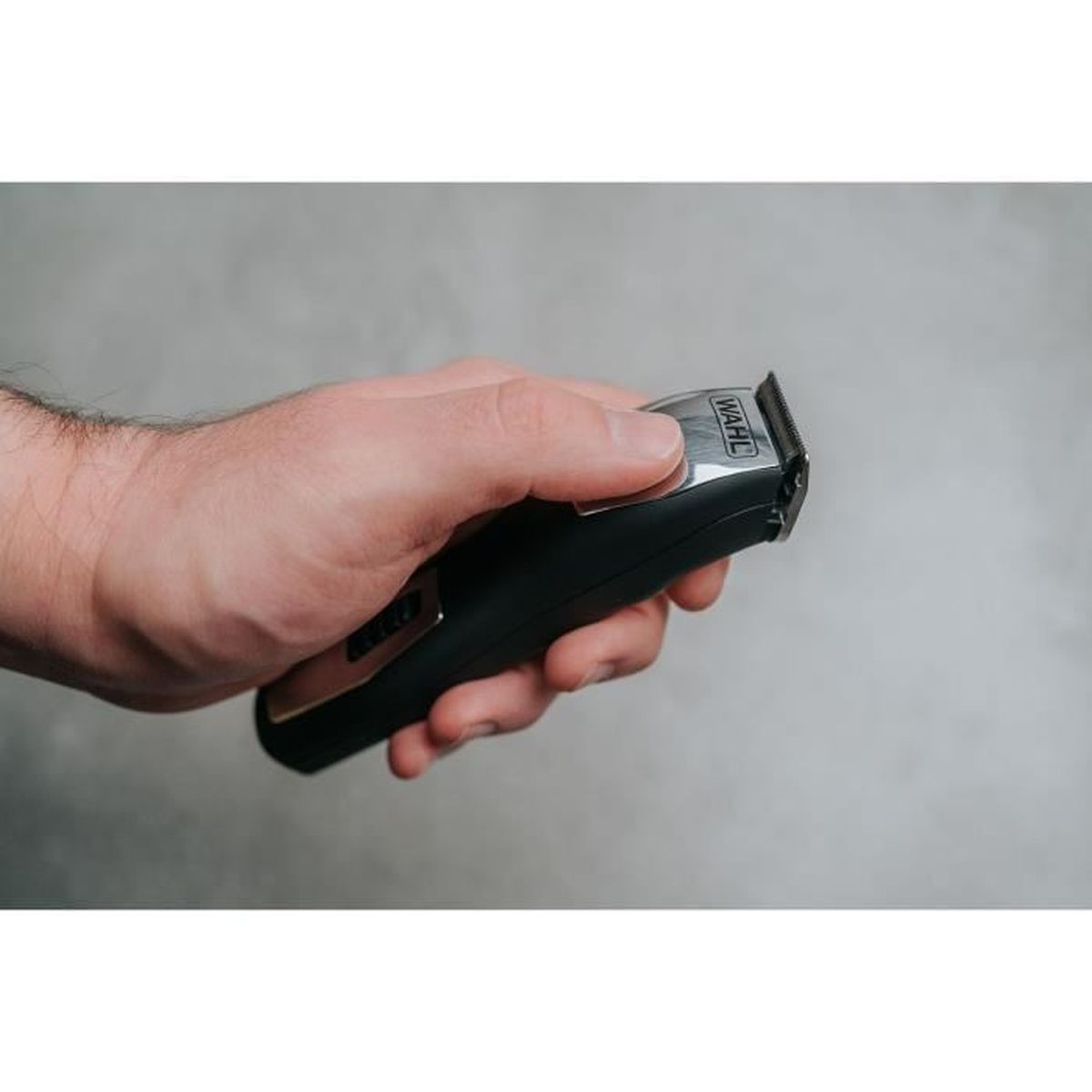 Eine Hand hält einen schwarzen Haartrimmer mit silbernen Akzenten.