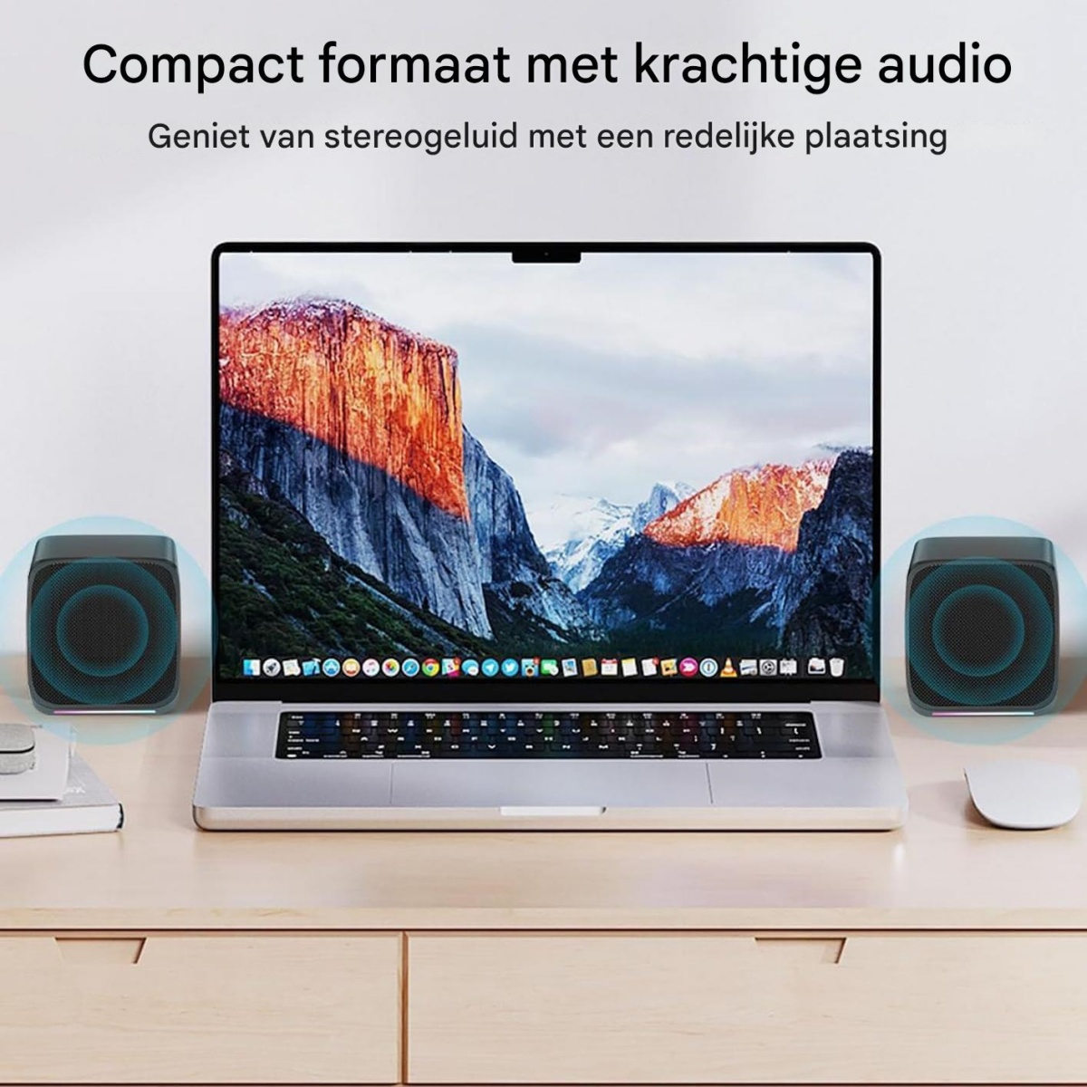 Zwei schwarze Lautsprecher stehen neben einem Laptop mit Berglandschaft.