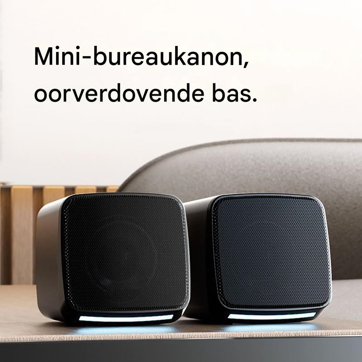 Zwei schwarze Mini-Lautsprecher mit weißer LED-Beleuchtung auf einem Tisch.