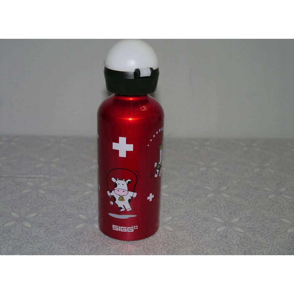 Rote SIGG-Flasche mit Kuh-Motiv und Schweizer Kreuz.
