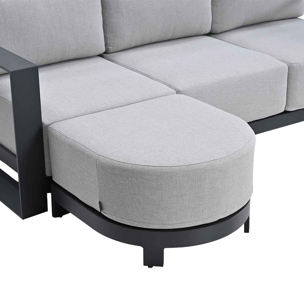 Grijze hoekbank met donker metalen frame en hocker.