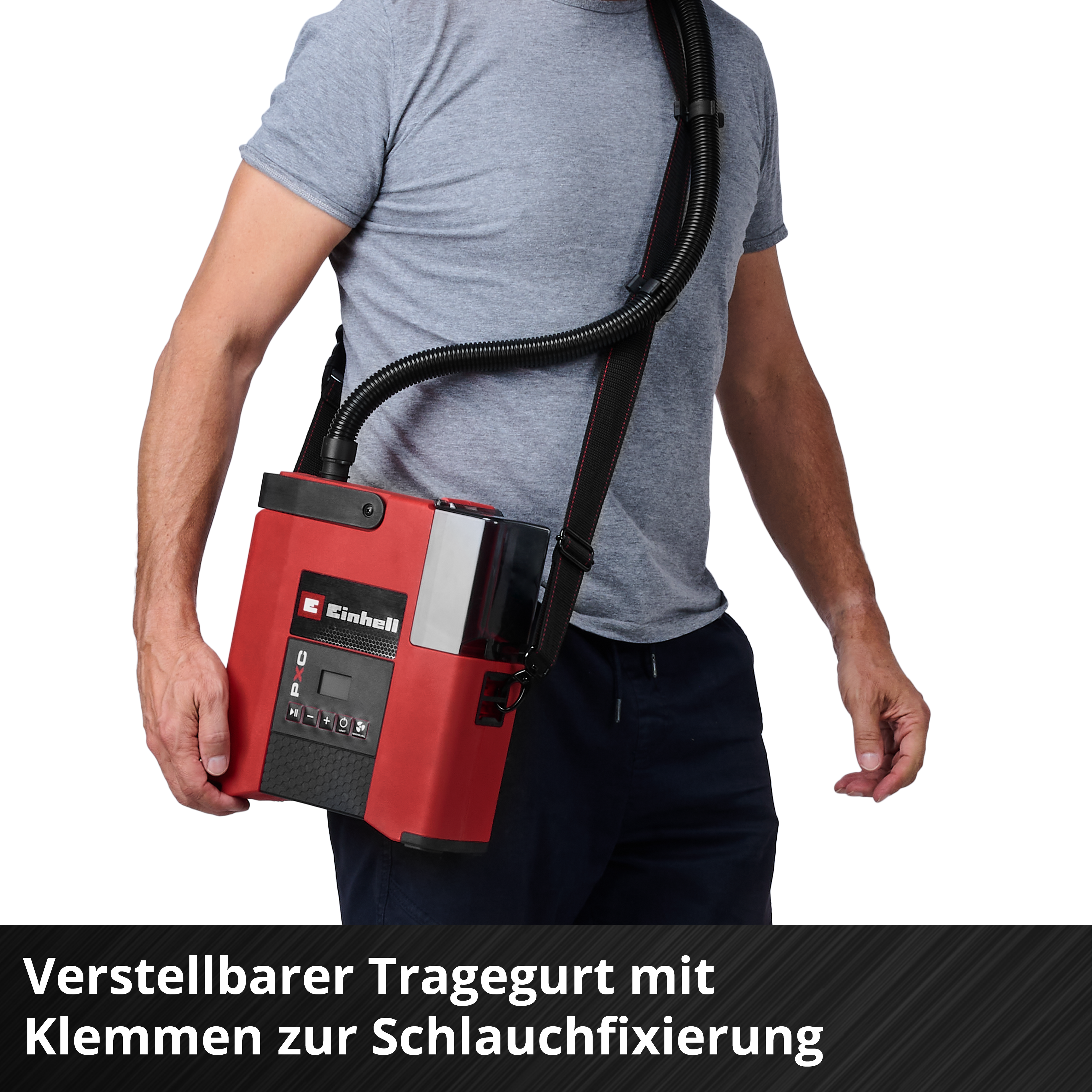 Ein Mann trägt ein rotes Gerät mit einem Schlauch über der Schulter.