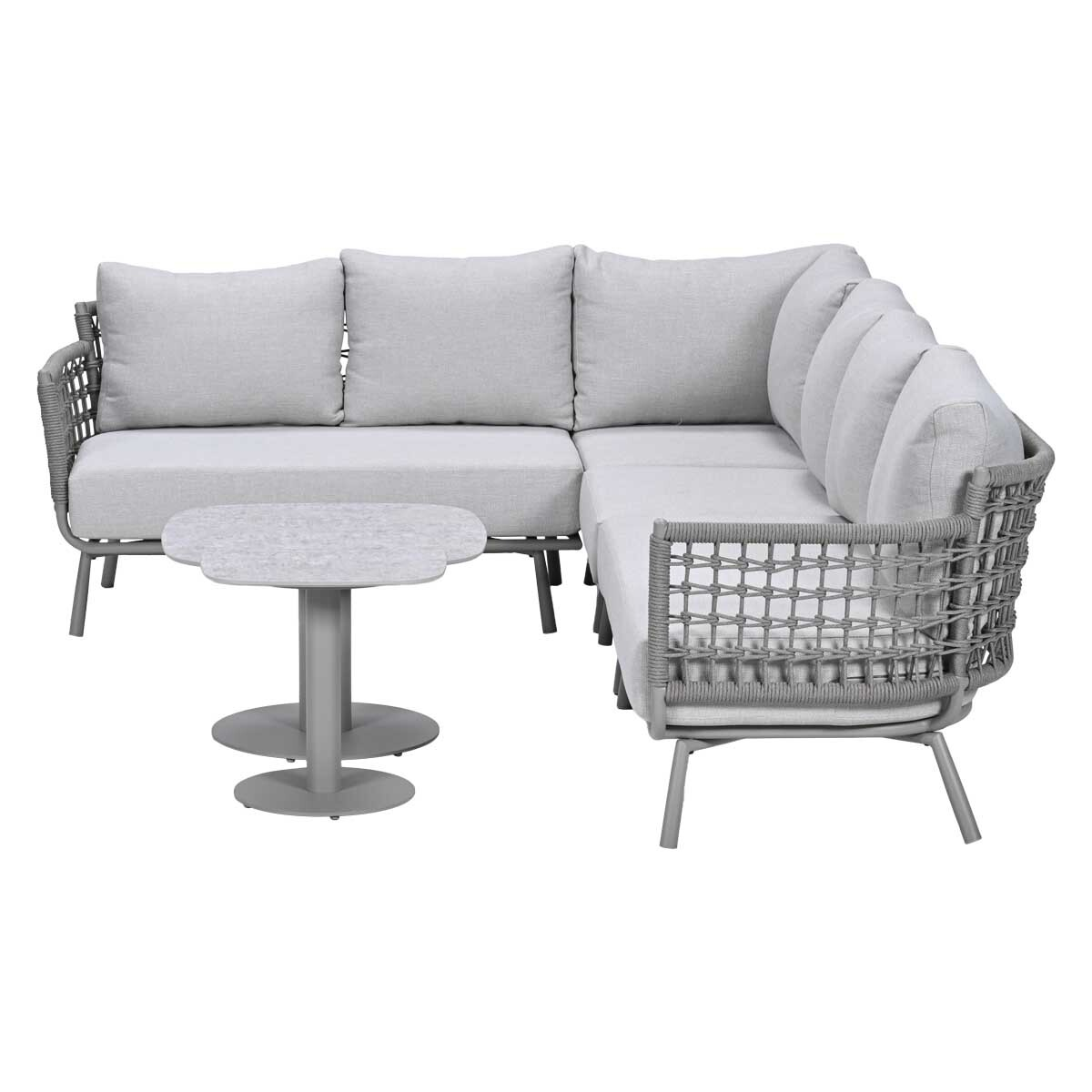 Gray sectional sofa with woven armrests and a small, flower-shaped table.