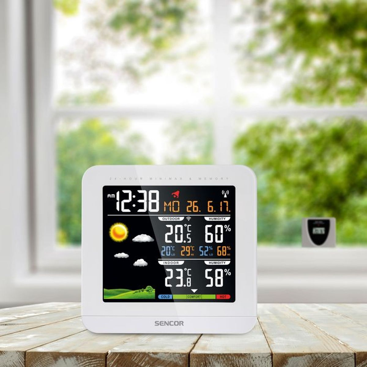 Biały wyświetlacz stacji pogodowej pokazuje czas, datę, temperaturę zewnętrzną i wewnętrzną oraz wilgotność.